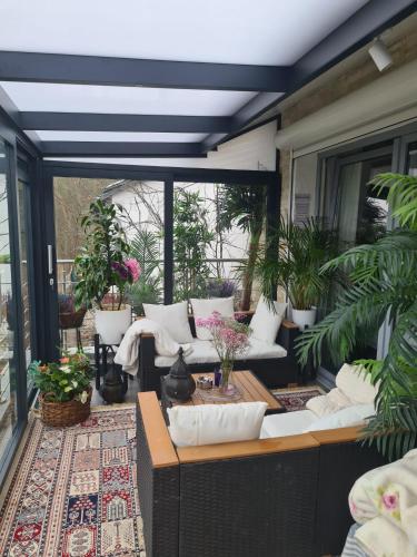 a patio with white couches and plants on a porch at Cozy room with a beautiful garden view in Baunatal