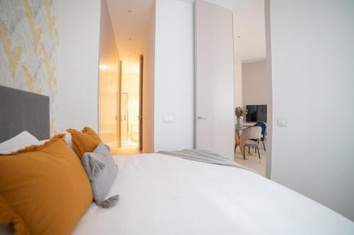 sypialnia z dużym białym łóżkiem z żółtymi poduszkami w obiekcie MyHouseSpain - Nuevo apartamento junto al Bernabéu w Madrycie