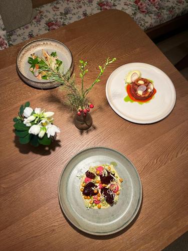 a table with plates of food and flowers on it at MAYER - Wirtshaus und Dorfhotel in Sankt Martin am Grimming