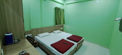 a room with a bed and a desk and a mirror at Hotel Aaditya Palace in Bhusāwal