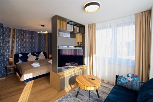 a bedroom with a bed and a tv and a couch at CITY PRESTIGE apartment Trencin in Trenčín