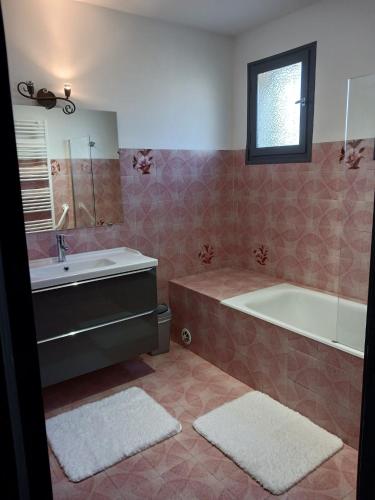 une salle de bain avec une baignoire et un lavabo dans l'établissement La Dindoulette a partir de 3 jours et plus sans piscine pour 6 personnes personnes, à Villeneuve