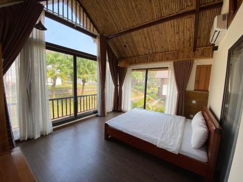 Thang Mây Village Rersort في بافي: غرفة نوم بسرير ونافذة كبيرة