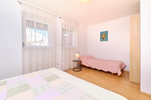 een slaapkamer met een bed en een raam bij Apartments Vanda in Mali Lošinj