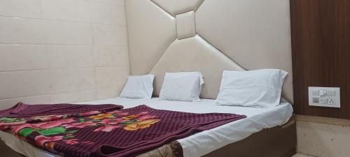 a bed with a purple blanket on top of it at Hotel Ajmer in Ajmer