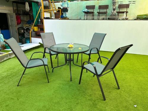 a table and chairs on a green floor with grass at King's Home Hua Hin Homestay in Hua Hin