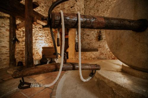 una cuerda colgada de un poste de madera en una habitación en Lo Molí de Rosquilles - Adults Only, en Masdenverge