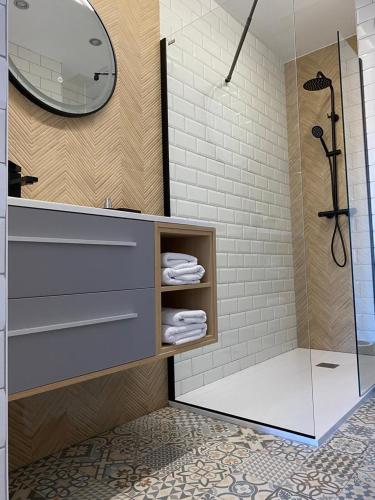 y baño con ducha y lavabo con toallas. en Exclusivo apartamento de diseño en PLAZA MAYOR VUT 09-449, en Burgos