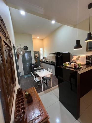 a kitchen with a table and a dining room at Dayahselamat Homestay in Temerloh