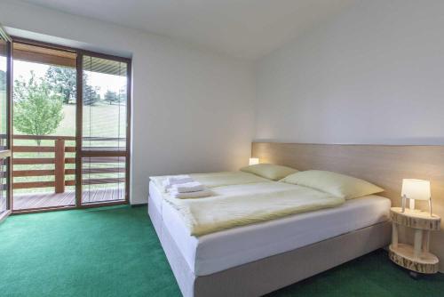 Rusava的住宿－Hotel Rusava 2 depandance，一间卧室设有一张大床和一个大窗户