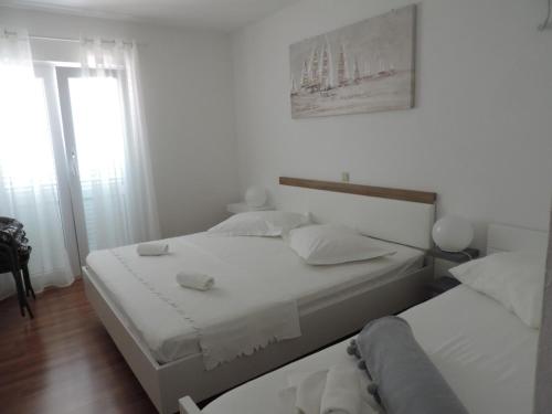 - une chambre blanche avec 2 lits et une fenêtre dans l'établissement Apartment in Brela with sea view, terrace, WiFi, washing machine 4947-2, à Brela
