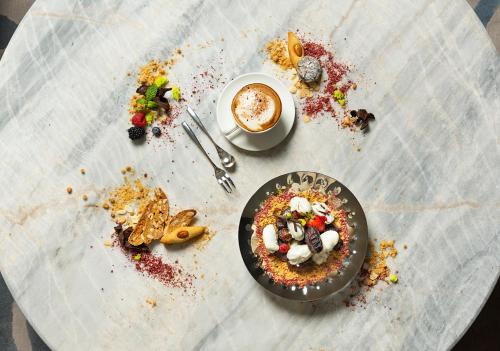 a table with a plate of food and a cup of coffee at Asiana Grand Hotel in Dubai