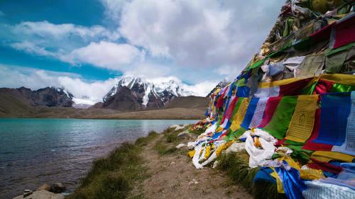 a row of prayer flags on the side of a lake at KhenKhim Regency, Lachen all meals included in Lachen