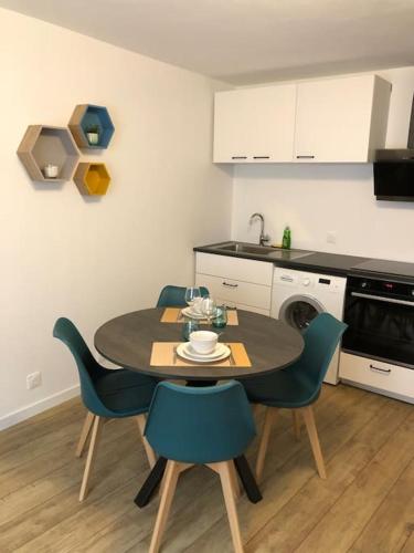 une cuisine avec une table et des chaises dans une cuisine dans l'établissement F2 au pied de la Basilique, à Saint-Nicolas-de-Port