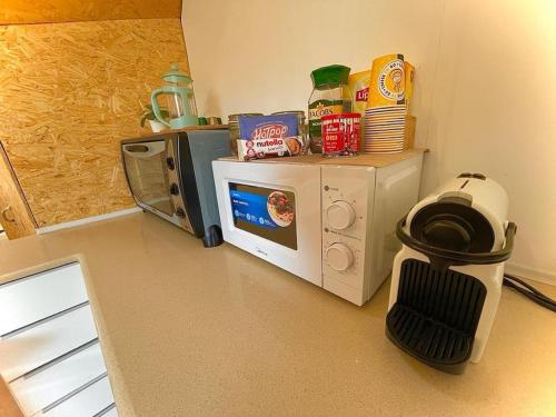 a kitchen with a microwave on a counter with a stove at Olive Dome - כיפה גיאודזית ענקית ומודרנית בין עצי הזית in Yavneʼel