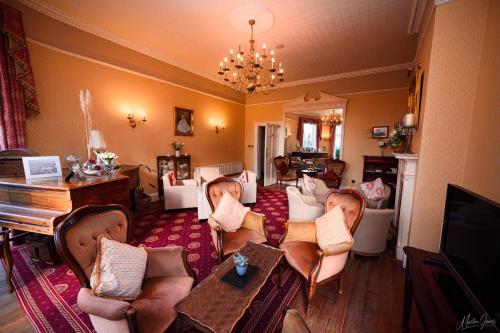 a living room filled with furniture and a piano at Old Rectory in Wem