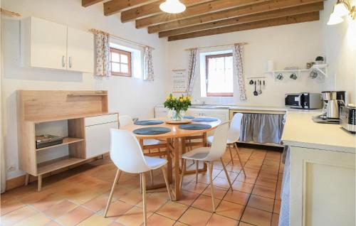 - une cuisine avec une table en bois et des chaises blanches dans l'établissement Gorgeous Home In St, Pierre Langers, à La Lucerne-dʼOutremer