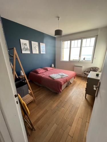 ヴィムルーにあるVilla Sainte Margueriteの青い壁の赤いベッドが備わるベッドルーム1室が備わります。