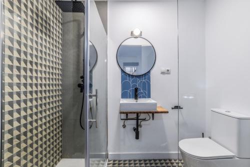 łazienka z prysznicem, umywalką i lustrem w obiekcie MyHouseSpain - Moderno apartamento ubicación inmejorable Madrid w Madrycie