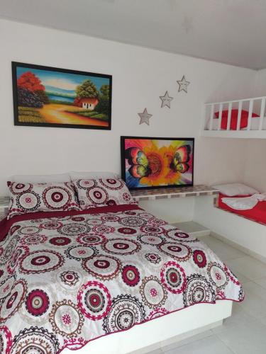 a bedroom with a bed and two paintings on the wall at PARAISO REAL in Isla Grande