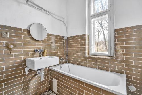 a bathroom with a tub and a sink and a window at Romantická Chalupa Louka in Louka