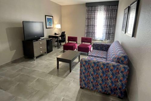 a living room with a couch and a tv at La Quinta Inn and Suites by Wyndham - Schertz in Schertz