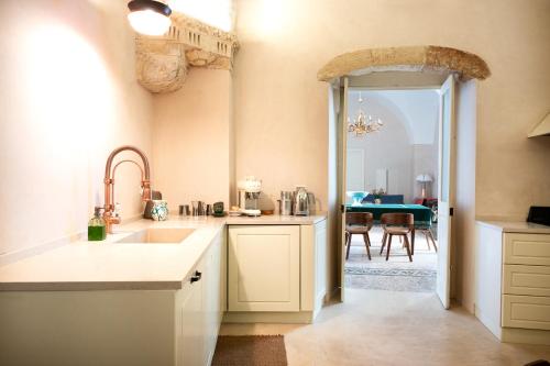 a kitchen with a sink and a dining room at Casa a Corte, Nardò in Nardò