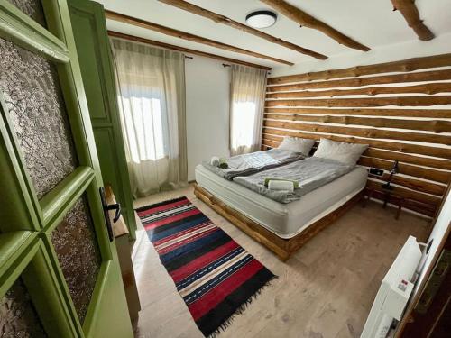 a bedroom with a bed and a wooden wall at Vista Verde in Oreshak