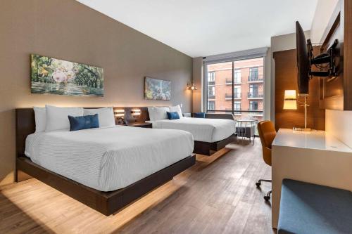 um quarto de hotel com duas camas e uma secretária em Cambria Hotel Savannah Downtown Historic District em Savannah