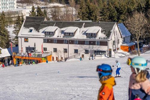 a group of people standing in the snow in front of a building at k1 sporthotel - Bike & Ski inklusive Hotel in Kurort Oberwiesenthal