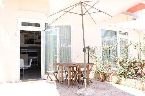 a wooden table with an umbrella on a patio at Hotel La Torraccia in Tarquinia