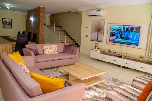 a living room with two couches and a tv at House 24 in Abuja