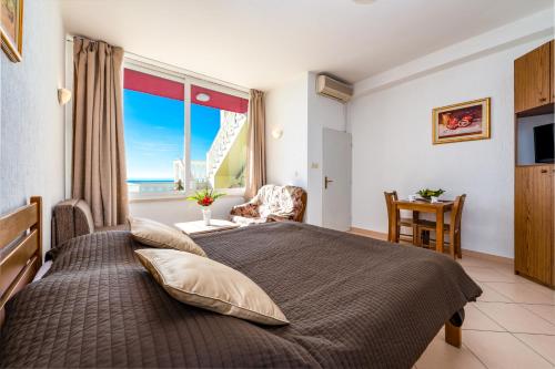 1 dormitorio con 1 cama grande y ventana grande en Amazing view apartment Slavica 3, en Dubrovnik