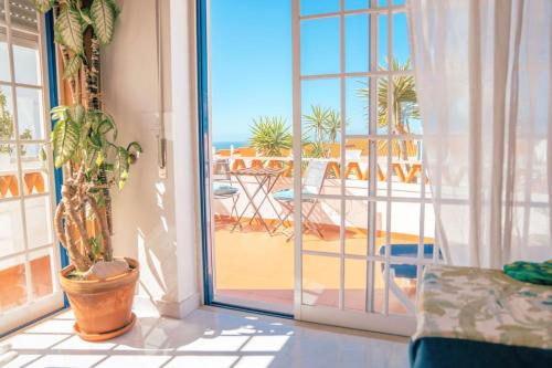 an open door to a patio with a view of the ocean at Ericeira Soulsurfers Guesthouse in Ericeira