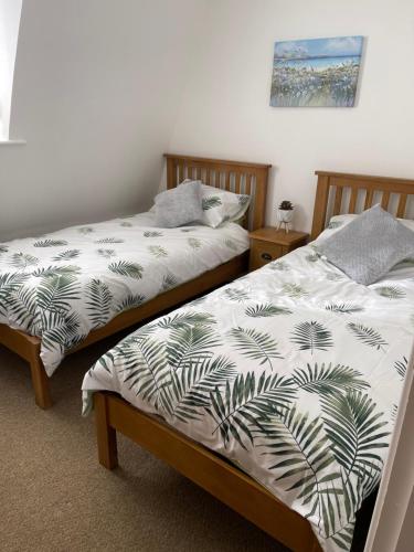 dos camas sentadas una al lado de la otra en un dormitorio en Yare Quays River View, en Great Yarmouth