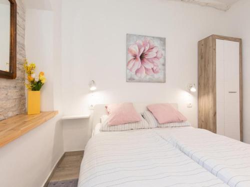 1 dormitorio blanco con 1 cama grande con almohadas rosas en Studio Apartment Sisi en Opatija
