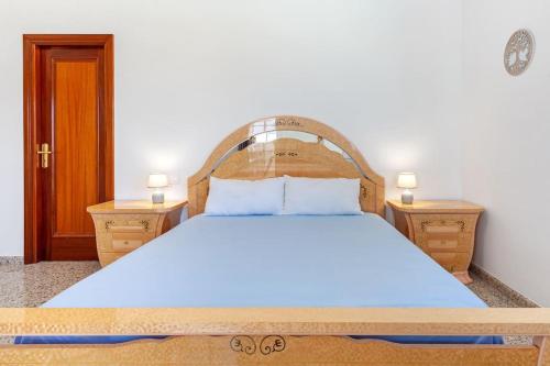 a bedroom with a large bed with a wooden headboard at Villa Marlenghi with Private Pool in San Bartolomé de Tirajana
