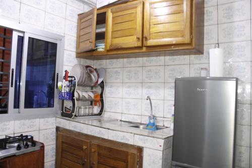 uma cozinha com um frigorífico de aço inoxidável e armários de madeira em Cozy Bay em Douala