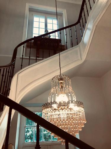 a chandelier hanging from a staircase with a window at Thomar House in Tomar