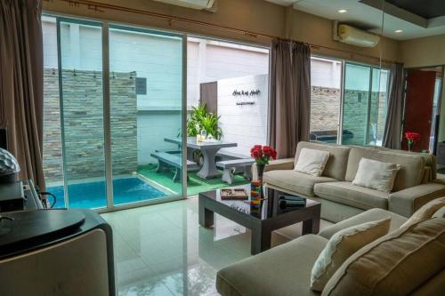 a living room with a couch and a table at Home to my heart pool villa in Jomtien Beach