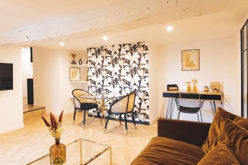 salon z kanapą i stołem w obiekcie Le Petit Martray - Au coeur du centre ville w mieście Lamballe