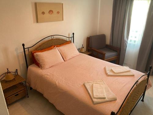 - une chambre dotée d'un lit avec des draps orange et une chaise dans l'établissement Apartamento Vila Nova 1, à Armação de Pêra
