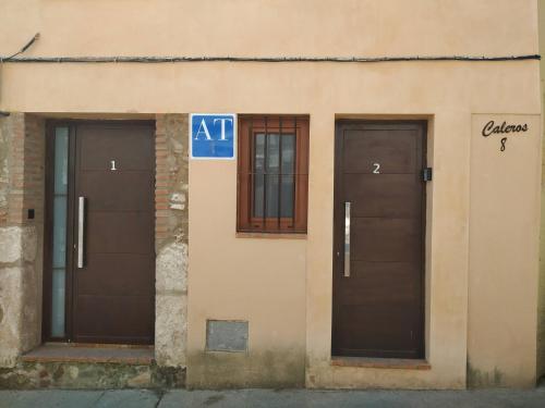 deux entrées d'un bâtiment avec deux portes de garage dans l'établissement Caleros 8 Apartamento - Apartamentos de la Parte Antigua de Cáceres, à Cáceres