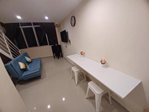 a living room with a white table and a blue chair at SY Staycation - Studio in Bayan Lepas