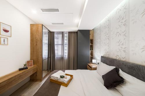ein Schlafzimmer mit einem großen weißen Bett und einem Fenster in der Unterkunft Volga Apartment by Downtown Inn in Yerevan