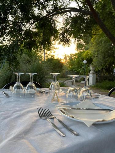 a white table with wine glasses and silverware on it at Agriturismo Tenuta la Monaca in Aradeo