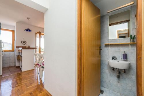 ein Badezimmer mit einem Waschbecken neben einer Küche in der Unterkunft Apartments Jonke in Mandre