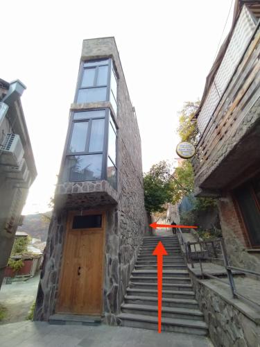 a building with a red arrow pointing to a door at Gogichas tower in Borjomi
