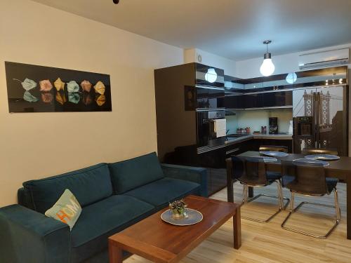 - un salon avec un canapé bleu et une table dans l'établissement SAS Apartamenty "Sapphire", à Szczecin