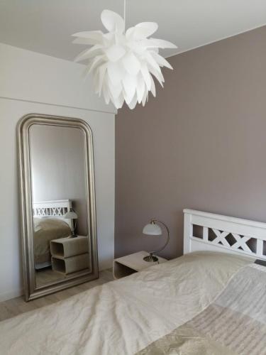 a bedroom with a large mirror and a bed at Parvekkeellinen huoneisto rantabulevardilla, 1-4 hengelle in Savonlinna